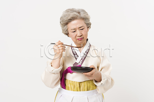 60대 노년 노인여자한명만 여자 한국인 한명 JPG 앞모습 포토 들기 먹기 명절 모션 상반신 서기 설날 숟가락 스튜디오촬영 실내 앞치마 응시 전통 접시 찡그림 추석 한국전통 한복 할머니