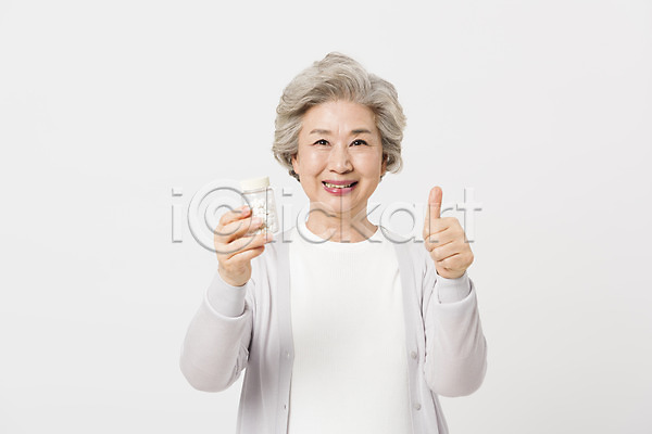 60대 노년 노인여자한명만 사람 여자 한국인 한명 JPG 근접촬영 앞모습 포토 건강 건강관리 들기 미소(표정) 상반신 서기 스튜디오촬영 실내 실버라이프 알약 약병 응시 최고 할머니