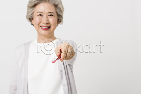 60대 노년 노인여자한명만 사람 여자 한국인 한명 JPG 앞모습 포토 건강 건강관리 들기 미소(표정) 상반신 서기 손내밀기 스튜디오촬영 실내 실버라이프 양치 응시 칫솔 할머니