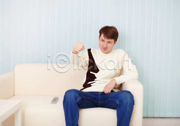 남자 사람 한명 JPG 포토 해외이미지 가로 멀리 미소(표정) 부채 스웨터 앉기 제어 주택 청바지 텔레비전 파란색 해외202004 회색 흰색