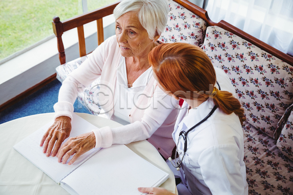 집중 노년 두명 성인 여자 여자만 JPG 포토 하이앵글 해외이미지 간호사 독서 라이프스타일 상반신 소파 손짚기 시각장애인 실내 앉기 점자 점자책 책상