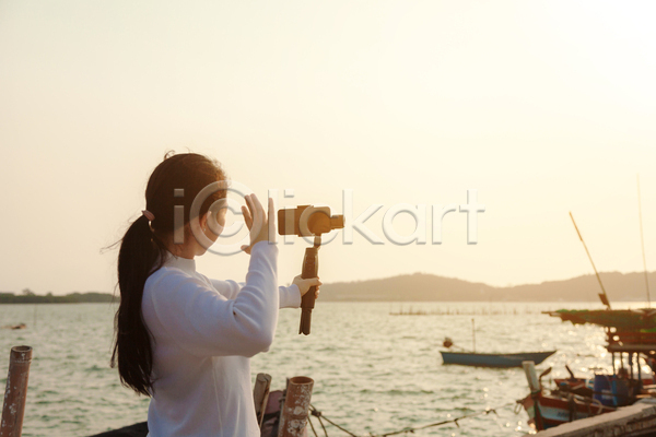 동양인 성인 성인여자한명만 여자 한명 JPG 포토 해외이미지 1인미디어 들기 바다 상반신 셀카봉 스트리밍 야외 영상촬영 유튜버 주간 카메라 크리에이터