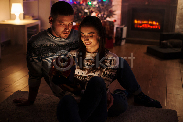 기쁨 사랑 행복 남자 두명 백인 성인 성인만 여자 JPG 포토 해외이미지 겨울 미소(표정) 빛 상자 선물 스웨터 실내 어둠 오픈 장식 커플 크리스마스