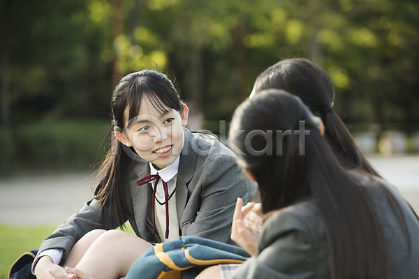 우정 즐거움 10대 사람 세명 십대여자만 여자 중학생 청소년 한국인 JPG 뒷모습 옆모습 포토 공원 교복 대화 미소(표정) 상반신 십대라이프스타일 앉기 야외 여중생 여학생 응시 잔디 주간 책가방 친구 학생