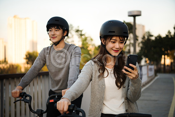 사랑 설레임 즐거움 행복 20대 남자 두명 사람 성인 성인만 여자 한국인 JPG 앞모습 포토 공원 공유자전거 광교호수공원 데이트 미소(표정) 상반신 수원 스마트폰 승차 안전 야외 운동 응시 자전거 주간 커플 헬멧