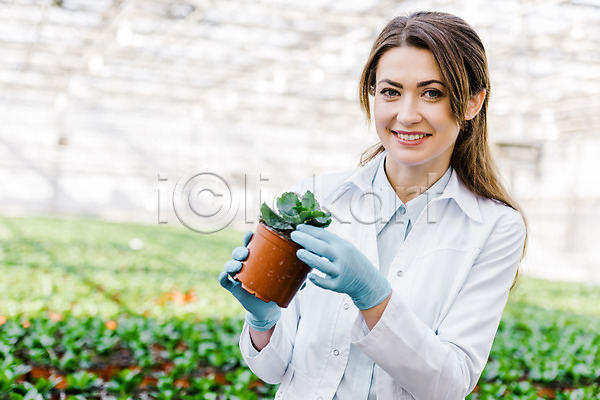 20대 사람 서양인 성인 성인여자한명만 여자 외국인 한명 JPG 앞모습 포토 들기 미소(표정) 상반신 생명공학 식물 실내 실험 연구복 연구원 온실 응시 잎 체코 화분