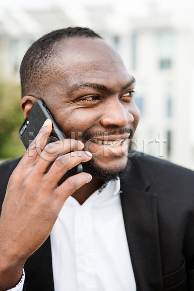 30대 남자 사람 서양인 성인남자한명만 외국인 한명 흑인 JPG 근접촬영 아웃포커스 앞모습 포토 들기 미소(표정) 비즈니스 비즈니스라이프 비즈니스맨 상반신 스마트폰 앉기 응시 직장인 체코 통화
