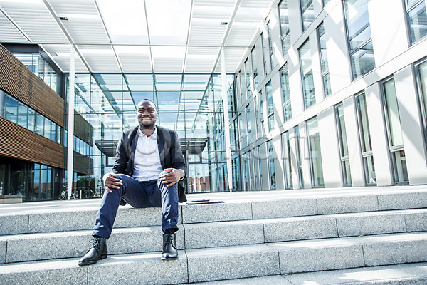 여유 휴식 30대 남자 사람 서양인 성인 성인남자한명만 외국인 한명 흑인 JPG 앞모습 포토 계단 미소(표정) 비즈니스 비즈니스라이프 비즈니스맨 빌딩 앉기 야외 웃음 응시 전신 주간 체코 회사