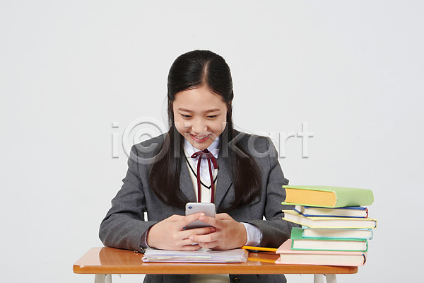 10대 십대여자한명만 여자 중학생 청소년 한국인 한명 JPG 앞모습 포토 교복 딴짓 상반신 수업 스마트폰 스튜디오촬영 실내 십대라이프스타일 앉기 여중생 여학생 연필 의자 책 책더미 책상 핸드폰 흰배경