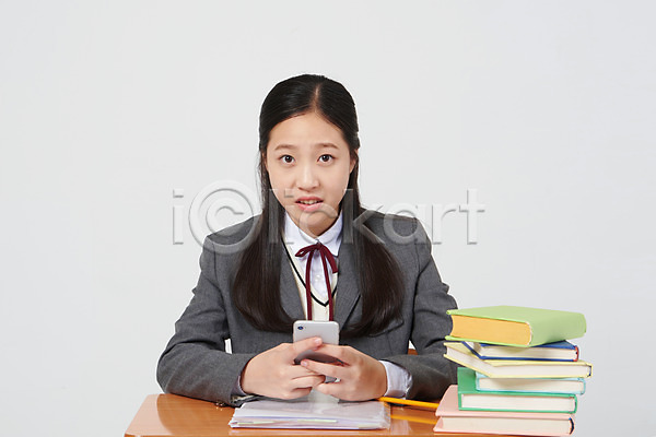 10대 십대여자한명만 여자 중학생 청소년 한국인 한명 JPG 앞모습 포토 교복 딴짓 상반신 수업 스마트폰 스튜디오촬영 실내 십대라이프스타일 앉기 여중생 응시 의자 책 책더미 책상 흰배경