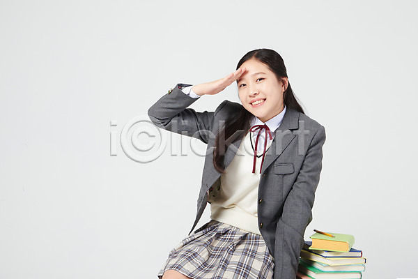 10대 십대여자한명만 여자 중학생 청소년 한국인 한명 JPG 앞모습 포토 걸터앉기 교복 미소(표정) 상반신 손 손들기 손짓 스튜디오촬영 실내 십대라이프스타일 여중생 여학생 응시 책 책더미 책상 흰배경