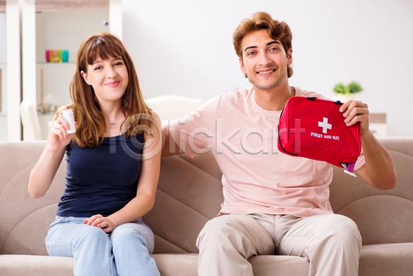 남자 두명 성인 성인만 여자 JPG 앞모습 포토 해외이미지 구급상자 들기 미소(표정) 상반신 소파 실내 앉기 약병 응급치료 커플