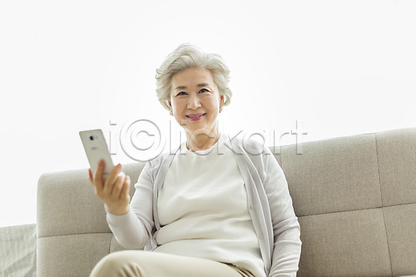 60대 노년 노인여자한명만 사람 여자 한국인 한명 JPG 앞모습 포토 다리꼬기 들기 미소(표정) 상반신 소파 스마트폰 스튜디오촬영 실내 실버라이프 앉기 응시 일상 할머니