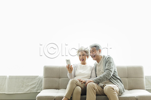 60대 70대 남자 노년 노인만 두명 사람 여자 한국인 JPG 앞모습 포토 노부부 다리꼬기 들기 미소(표정) 상반신 소파 스마트폰 스튜디오촬영 실내 실버라이프 앉기 영상통화 웃음 응시 일상 할머니 할아버지