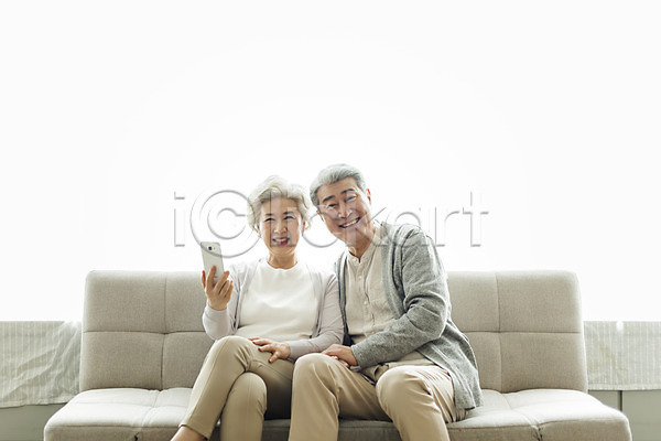 60대 70대 남자 노년 노인만 두명 사람 여자 한국인 JPG 앞모습 포토 노부부 들기 미소(표정) 상반신 소파 스마트폰 스튜디오촬영 실내 실버라이프 앉기 응시 일상 할머니 할아버지