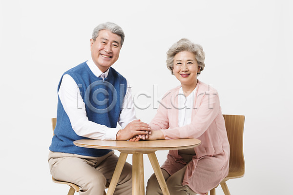 60대 70대 노년 노인만 두명 사람 한국인 JPG 앞모습 포토 노부부 미소(표정) 상반신 손잡기 스튜디오촬영 실내 실버라이프 앉기 응시 의자 일상 책상 할머니 할아버지 흰배경