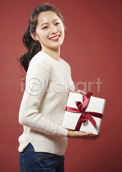 따뜻함 사랑 행복 20대 사람 성인 성인여자한명만 여자 한국인 한명 JPG 옆모습 포토 들기 리본 미소(표정) 빨간배경 상반신 선물 선물상자 스튜디오촬영 실내 여대생 응시 의료성형뷰티 포장