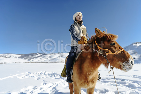 20대 사람 성인 성인여자한명만 여자 한국인 한명 JPG 로우앵글 앞모습 포토 겨울 고삐 눈(날씨) 말(동물) 몽골 미소(표정) 산 설원 승마 앉기 야외 여행 응시 잡기 장갑 전신 주간 한마리