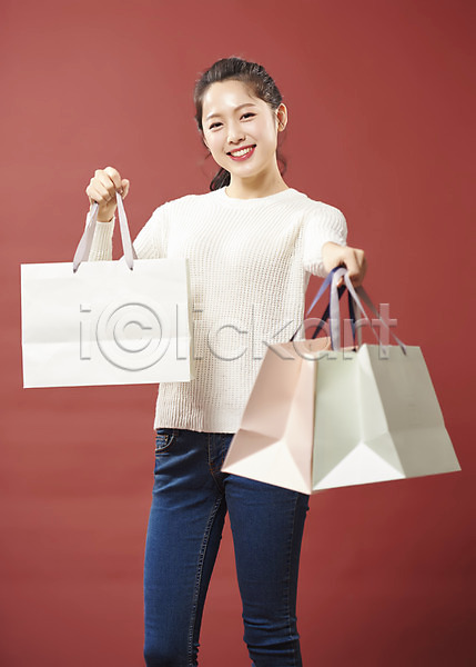 20대 사람 성인 성인여자한명만 여자 한국인 한명 JPG 앞모습 포토 들기 라이프스타일 미소(표정) 뷰티 빨간배경 상반신 세일 쇼핑 쇼핑백 스튜디오촬영 실내 여대생 응시 의료성형뷰티 캐주얼 할인혜택
