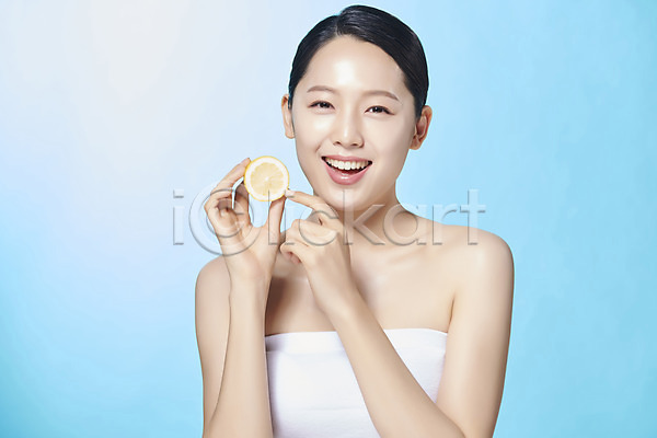 상큼 20대 사람 성인 성인여자한명만 여자 한국인 한명 JPG 앞모습 포토 가리킴 누끼 디톡스 레몬 모션 미소(표정) 반쪽 뷰티 상반신 스튜디오촬영 실내 싱그러움 응시 의료성형뷰티 파란배경