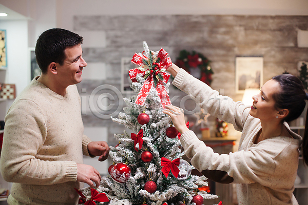 사랑 준비 즐거움 함께함 남자 두명 성인 성인만 여자 JPG 옆모습 포토 해외이미지 겨울 꾸미기 라이프스타일 매달리기 미소(표정) 부부 상반신 실내 크리스마스 크리스마스장식 크리스마스트리