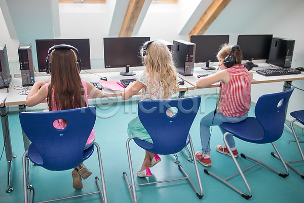 집중 10대 사람 서양인 세명 어린이 어린이만 여자 외국인 JPG 뒷모습 포토 교육 수업 스쿨라이프 실내 앉기 응시 전신 체코 컴퓨터 컴퓨터교육 컴퓨터실 학교 헤드셋