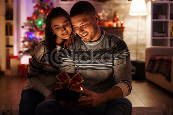 기쁨 사랑 행복 남자 두명 백인 성인 성인만 여자 JPG 포토 해외이미지 겨울 미소(표정) 빛 상자 선물 스웨터 실내 어둠 오픈 장식 커플 크리스마스