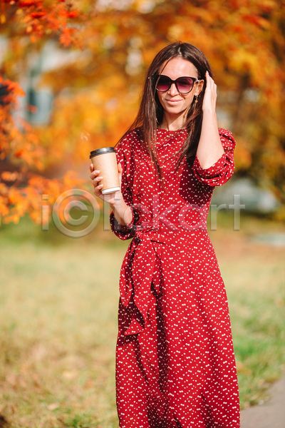 성인 성인여자한명만 여자 한명 JPG 아웃포커스 앞모습 포토 해외이미지 가을(계절) 공원 들기 미소(표정) 상반신 선글라스 손짓 테이크아웃컵