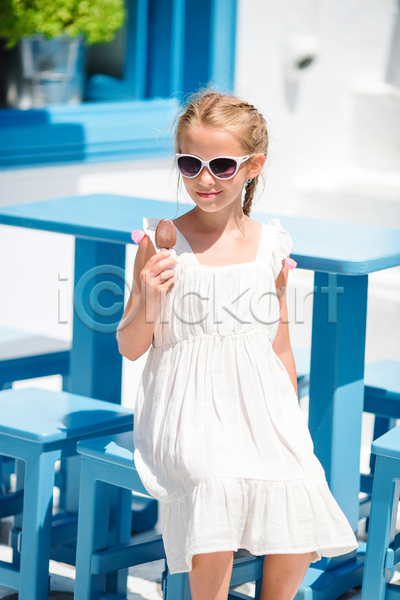 휴식 소녀(어린이) 소녀한명만 어린이 여자 한명 JPG 앞모습 포토 해외이미지 들기 막대아이스크림 미코노스섬 바캉스 상반신 선글라스 앉기 야외 여름(계절) 여름휴가 원피스 의자 주간 탁자 파란색 흰색