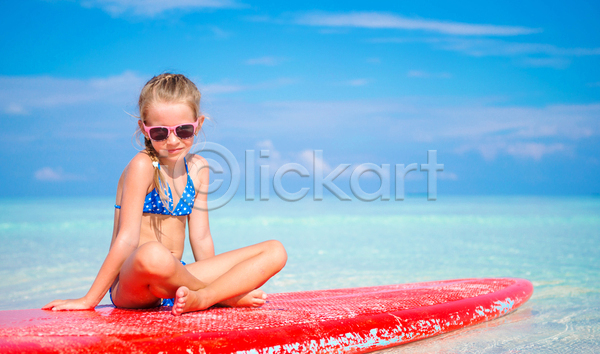 소녀(어린이) 소녀한명만 어린이 여자 한명 JPG 앞모습 포토 해외이미지 바다 서핑보드 선글라스 수영복 승차 앉기 야외 전신 주간 해변