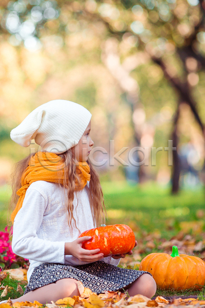 소녀(어린이) 소녀한명만 어린이 여자 한명 JPG 아웃포커스 옆모습 포토 해외이미지 가을(계절) 공원 낙엽 들기 앉기 응시 잔디 전신 호박