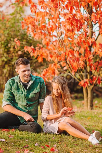 남자 두명 성인 소녀(어린이) 어린이 여자 JPG 소프트포커스 앞모습 포토 해외이미지 가을(계절) 공원 단풍 단풍나무 들기 미소(표정) 부녀 앉기 응시 잔디 전신