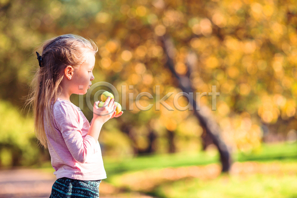소녀(어린이) 소녀한명만 어린이 여자 한명 JPG 아웃포커스 옆모습 포토 해외이미지 가을(계절) 공원 과일 들기 상반신 햇빛
