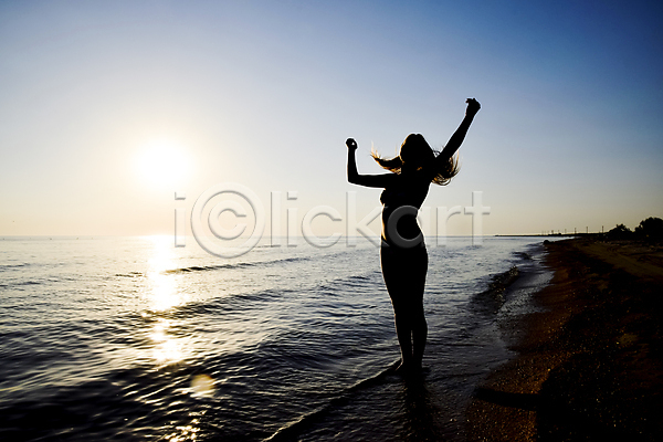 성인 성인여자한명만 여자 한명 JPG 실루엣 포토 해외이미지 바다 서기 손들기 야외 여름(계절) 일몰 전신 파도 풍경(경치) 햇빛 휴가