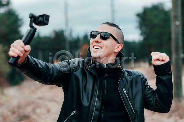남자 성인 성인남자한명만 한명 JPG 앞모습 포토 해외이미지 1인미디어 가죽자켓 들기 상반신 선글라스 셀프카메라 셀프캠 야외 주간 카메라 크리에이터