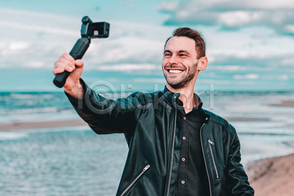 남자 성인 성인남자한명만 한명 JPG 앞모습 포토 해외이미지 1인미디어 가죽자켓 들기 상반신 셀프카메라 셀프캠 야외 여행 주간 카메라 크리에이터 해변