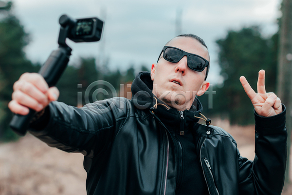 남자 성인 성인남자한명만 한명 JPG 앞모습 포토 해외이미지 1인미디어 가죽자켓 들기 브이 상반신 선글라스 셀프카메라 셀프캠 야외 주간 카메라 크리에이터