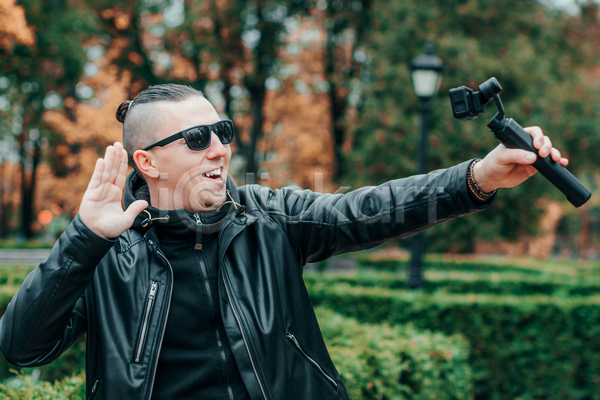 남자 성인 성인남자한명만 한명 JPG 앞모습 포토 해외이미지 1인미디어 가죽자켓 들기 상반신 선글라스 셀프카메라 셀프캠 야외 주간 카메라 크리에이터