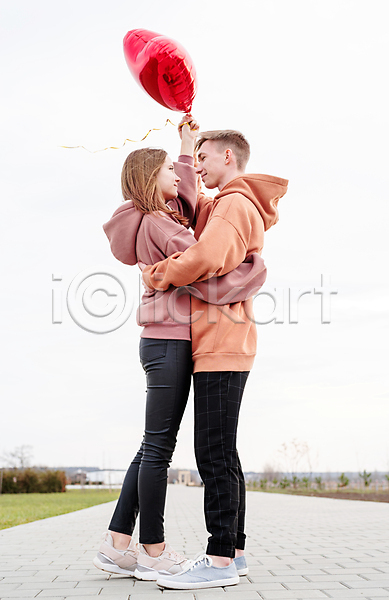 사랑 남자 두명 성인 성인만 여자 JPG 포토 해외이미지 들기 마주보기 야외 잡기 전신 주간 커플 포옹 풍선 하트 하트풍선