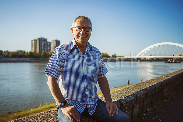 행복 휴식 남자 노년 백인 사람 성인 한명 JPG 포토 해외이미지 강 건강 도시 라이프스타일 맑음 미소(표정) 백발 앉기 야외 여름(계절) 은퇴 응시