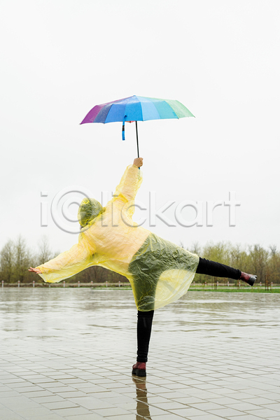 성인 성인여자한명만 여자 한명 JPG 뒷모습 포토 해외이미지 다리들기 들기 비(날씨) 야외 우비 우산 전신 주간 팔벌리기 포즈 하늘 한발서기