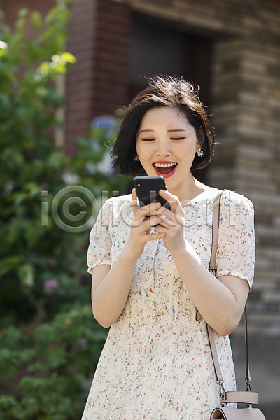기쁨 즐거움 20대 성인 성인여자한명만 여자 한국인 한명 JPG 앞모습 포토 거리 놀람 들기 미소(표정) 상반신 서기 스마트폰 싱글라이프 야외 여름(계절) 우먼라이프 원피스 응시 인싸 주간 취업준비생