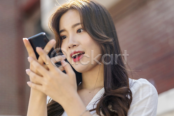 스마트 즐거움 20대 성인 성인여자한명만 여자 한국인 한명 JPG 로우앵글 앞모습 포토 거리 들기 상반신 서기 스마트폰 싱글라이프 야외 여름(계절) 우먼라이프 음성인식 응시 인싸 주간