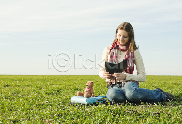 여유 성인 성인여자한명만 여자 한명 JPG 앞모습 포토 해외이미지 곰인형 독서 목도리 앉기 자연 잔디 전신 책 하늘