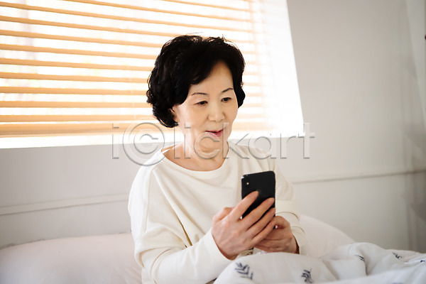 계획 편안함 60대 노년 노인여자한명만 사람 여자 한국인 한명 JPG 앞모습 포토 들기 상반신 스마트폰 실내 실버라이프 알람 응시 졸혼 침대 침실 확인