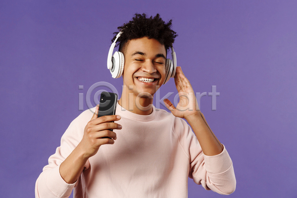 즐거움 남자 성인 성인남자한명만 한명 JPG 앞모습 포토 해외이미지 들기 상반신 스마트폰 실내 웃음 음악감상 헤드셋
