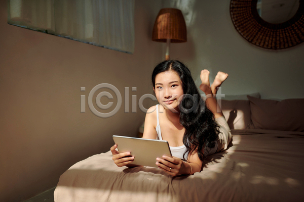여유 휴식 동양인 성인 성인여자한명만 여자 한명 JPG 앞모습 포토 해외이미지 들기 실내 엎드리기 전신 집콕 침대 침실 태블릿