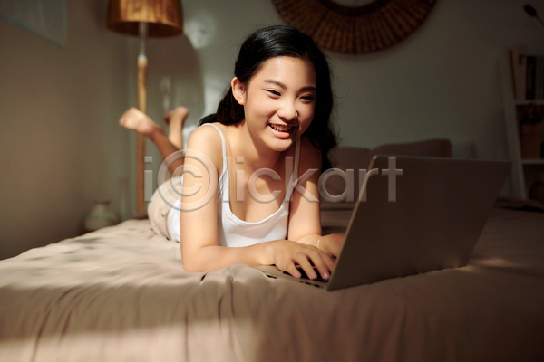 여유 즐거움 휴식 동양인 성인 성인여자한명만 여자 한명 JPG 앞모습 포토 해외이미지 노트북 실내 엎드리기 웃음 전신 집콕 침실