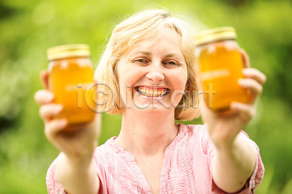 40대 사람 서양인 여자 외국인 중년 중년여자한명만 한명 JPG 앞모습 포토 꿀 꿀벌 농업 들기 미소(표정) 벌꿀 상반신 서기 야외 양봉 양봉업 유리병 응시 체코