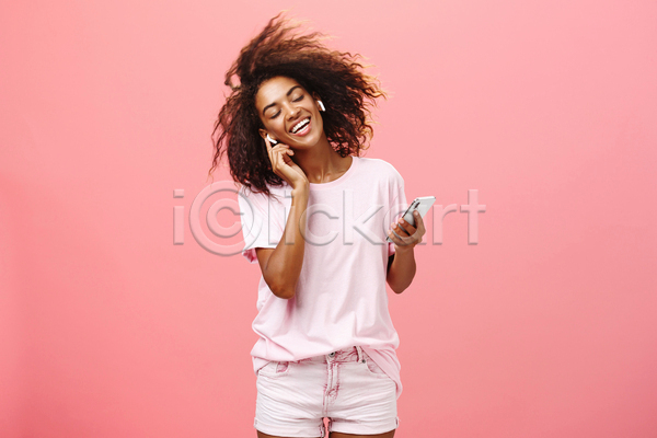 즐거움 성인 성인여자한명만 여자 한명 흑인 JPG 앞모습 포토 해외이미지 눈감음 들기 무선이어폰 분홍색 상반신 실내 웃음 음악감상